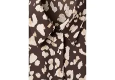 Camisa de poliéster con estampado animal print en tonos marrón y beige, cuello clásico y cierre frontal con botones.