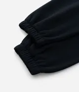 Pantalón jogger de corte holgado, confeccionado en tejido fleece color beige. Presenta cintura elástica, bolsillos laterales y puños ajustados en el bajo.