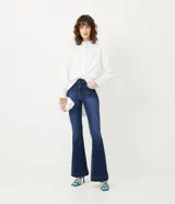 Pantalón de jean estilo flare con tiro alto, cierre de botón y cremallera, y bolsillos delanteros y traseros. Confeccionado en tejido de algodón con un toque de elastano para mayor comodidad.
