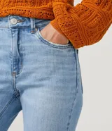 Pantalón de jean modelo slim con cintura mediana, trabillas para cinturón y bolsillos funcionales. Presenta un diseño clásico con acabado en el bajo.