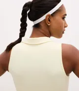 Vestido deportivo evasé color amarillo claro, confeccionado en microfibra. Presenta cuello polo con escote en V, diseño sin mangas y short interno incorporado con bolsillo lateral.