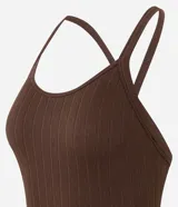 Body marrón oscuro de tejido acanalado, con escote redondo y breteles finos que se cruzan en la espalda.
