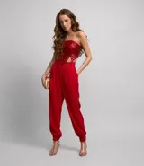 Pantalón jogger rojo de crepé con pliegues, bolsillos laterales y cierre frontal con cremallera.