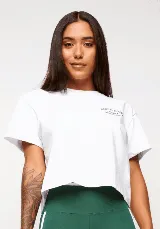 Remera blanca de algodón con corte crop, mangas cortas y estampado frontal con texto y logo en color gris.