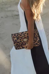 Sobre de mano con estampado de leopardo y cierre metálico dorado.