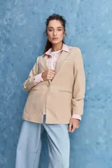 Blazer de corte sastrero con silueta relajada, solapas tradicionales, cierre frontal de un botón y bolsillos de vivo.