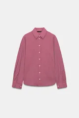 Camisa de manga larga con cuello solapa y cierre frontal de botones. Presenta un diseño de rayas verticales finas en color rojo y blanco, con bajo ligeramente asimétrico.