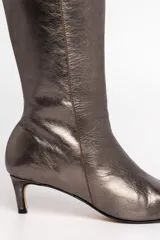 Bota de cuero vacuno metalizado color peltre, de caña alta y calce ajustado.