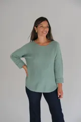 Sweater de tejido de punto color verde agua, con escote redondo a la base y mangas largas con puños doblados. Presenta un corte holgado con ruedo redondeado.