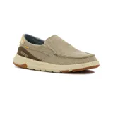 Zapato casual tipo slip-on de lona color kaki, con elásticos laterales, detalles en marrón y suela de goma con tecnología de amortiguación.