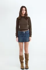 Sweater de punto color marrón, de corte básico con cuello redondo, manga larga y detalles de rib elástico en puños y cintura.