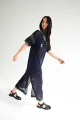 Remerón tejido de punto color azul marino con calados, cuello estilo camisa en verde oscuro con rayas blancas y verdes, y logo bordado en blanco en el pecho.