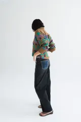 Buzo tejido de algodón negro con diseño jacquard de flores multicolor, cuello en V y mangas largas.