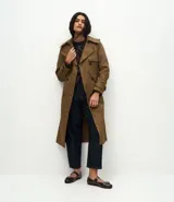 Suéter de punto pesado con diseño de cuadros argyle en tonos marrón y negro, con detalles de puntos claros. Presenta un corte oversize, cuello redondo acanalado y mangas largas.