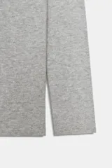 Jersey de punto liso color negro, con escote recto tipo off-shoulder con vuelta y manga larga.