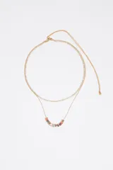 Collar doble dorado, compuesto por una cadena fina con incrustaciones de cristales y otra cadena con dijes cúbicos esmaltados en diferentes colores que forman letras.