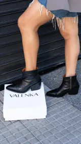 Botas cortas de cuero negro con diseño de estilo western, punta fina y taco cuadrado de 5.5 cm. Cuentan con cierre lateral y suela de goma.