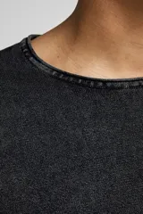 Sweater negro de punto ligero con cuello redondo y mangas largas. Tiene un tratamiento de lavado ácido para un aspecto deslavado y una superficie más suave.