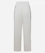 Pantalón deportivo de corte oversized estilo college, confeccionado en microfibra color crema con rayas laterales contrastantes en color marrón. Presenta cintura fija, bolsillos funcionales y frisos frontales.