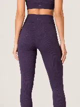 Calza deportiva de talle alto con diseño seamless (sin costuras) en color violeta, con paneles acanalados que realzan la silueta.