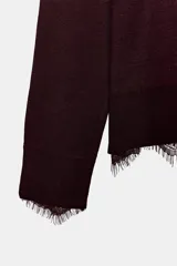 Jersey de punto fino color bordó con cuello redondo y manga larga. Presenta un delicado detalle de encaje a tono en el ruedo y en los puños.