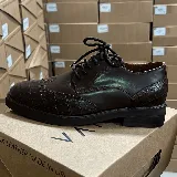 Zapato acordonado de cuero marrón con puntera y talón con textura de cocodrilo.