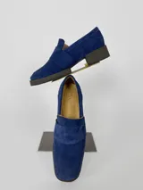 Mocasines de cuero azul con detalle de costuras en la parte delantera y suela de goma negra.