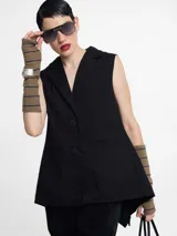 Chaleco sastrero negro con pinzas en la espalda, largo irregular y botones en la delantera.