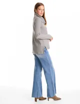 Buzo de punto color bordó con cuello volcado amplio y mangas largas. Presenta una costura central vertical en el frente y diseño con tajos laterales en el ruedo, siendo ligeramente más largo en la parte posterior.