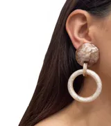 Aros colgantes con un diseño moderno y elegante. Cuentan con un ajuste de clip y están hechos de resina.