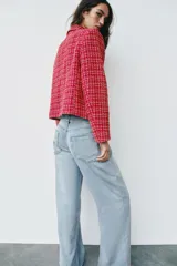 Blazer cruzado de tweed rojo con patrón texturizado en tonos blanco y negro, cuello con solapa, manga larga y cierre frontal con un botón.