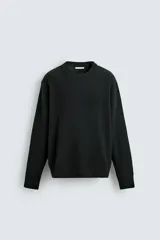 Jersey de punto con corte regular fit, cuello redondo y manga larga. Presenta un diseño de textura acanalada con acabados en rib en puños y bajo.