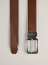 Cinturón reversible de cuero color marrón y negro, con hebilla metálica plateada.