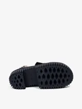 Sandalias doradas con plataforma negra y base amarilla. Tiras anchas y acolchadas de piel de oveja.