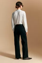 Jean azul oscuro de corte wide leg, con tiro alto, bolsillos frontales tipo parche y bajo deshilachado.