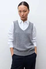 Chaleco de tejido de punto con escote en V y terminaciones acanaladas en cuello y sisas.