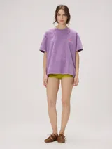 Remera oversize de corte cuadrado, color lila con efecto acid wash, cuello redondo y pequeño gráfico frontal en color rojo.