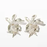 Aros colgantes con forma de flor plateada con perlas.