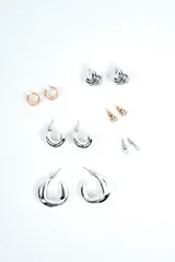 Set de aros variados que incluye pares de argollas plateadas de distintos tamaños, aros abridores con circón y perlas, y aros dorados de diseño geométrico.