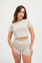 Remera corta de lycra color visón, de corte ajustado y mangas cortas.