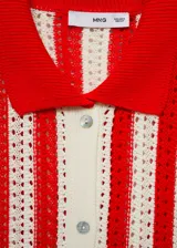 Cardigan de punto calado con diseño de rayas verticales en color rojo y crema. Presenta cuello camisero, cierre frontal con botones y mangas tres cuartos.