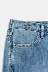 Jeans de tiro alto con pernera ancha y costuras marcadas en el frente. Presenta cintura elástica en la parte posterior, cierre frontal con cremallera y botón, bolsillos delanteros y bolsillos de plastrón en la parte trasera.