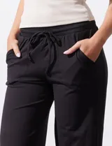 Pantalón jogger color crema, de corte ancho, con pretina elastizada y lazo de ajuste.