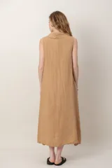 Vestido midi de lino color verde militar, sin mangas, con escote buche y bolsillos laterales, de corte relajado y fluido.