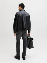 Jean tapered de hombre color negro con acabado lavado, tiro bajo y diseño clásico de cinco bolsillos.