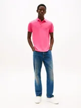 Chomba rosa de corte regular, con cuello tipo chomba, cartera de dos botones y logo de Tommy Hilfiger bordado en el pecho.