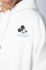 Buzo tipo canguro color negro con capucha y cordones ajustables. Presenta un pequeño estampado en el pecho con la silueta de Mickey Mouse y un detalle a cuadros en color verde.