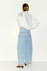 Jean tobillero de cinco bolsillos en denim de algodón rígido, con diseño curvo y volumen en las piernas de tiro alto.