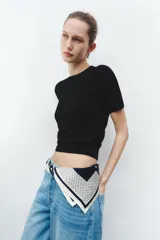 Jersey de punto fino con cuello redondo y manga corta, con terminaciones en rib en cuello, mangas y ruedo.