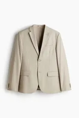 Blazer color beige de corte slim fit, con solapas de muesca finas, ojal decorativo, botonadura sencilla, bolsillo superior insertado, bolsillos delanteros con solapa, dos bolsillos interiores, botones decorativos en los puños y abertura doble en la parte posterior.